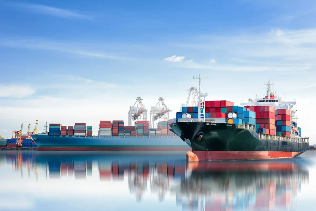 Two large cargo ships loaded with colorful shipping containers docked at a port with cranes in the background, representing maritime commerce and legal matters.